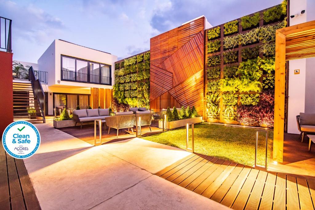 a building with a patio with furniture in front of it at Villa Esmeralda in Ponta Delgada