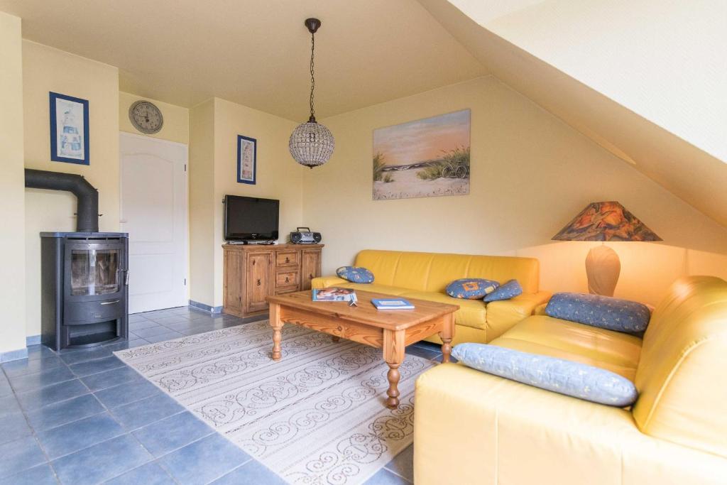 ein Wohnzimmer mit einem gelben Sofa und einem Tisch in der Unterkunft Strandoase Typ STO-A STRANDOASE Whg. SO7 in Wustrow