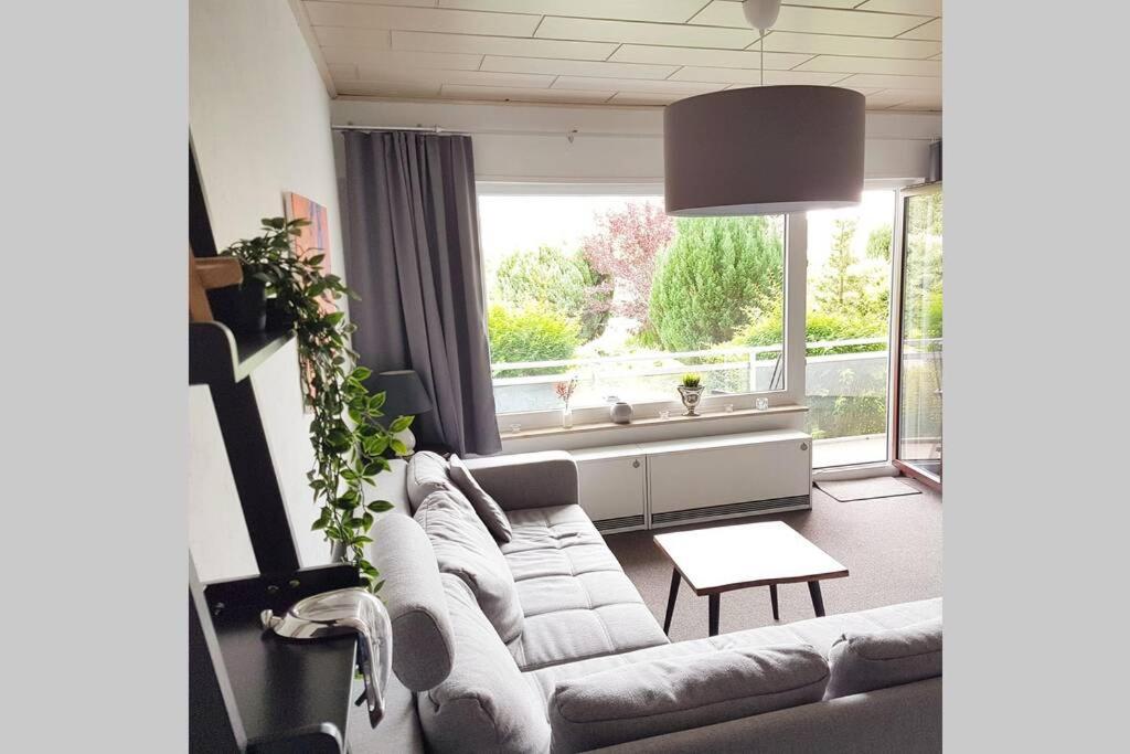 uma sala de estar com um sofá e uma grande janela em Altenauer Waldfrische em Altenau