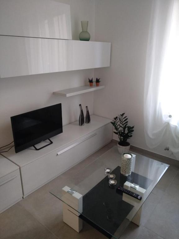 salon z telewizorem na białej ścianie w obiekcie Angel B&B w mieście Potenza Picena