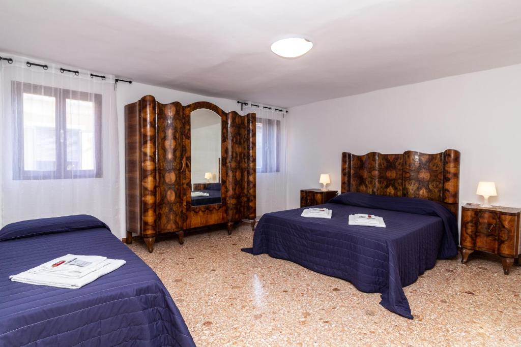 a bedroom with two beds and a mirror at Veneziacentopercento Ole Apartment in Venice