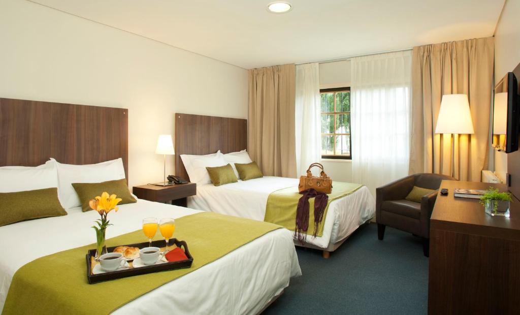 Habitación de hotel con 2 camas y bandeja de comida en Hotel Bahia Redonda en El Calafate