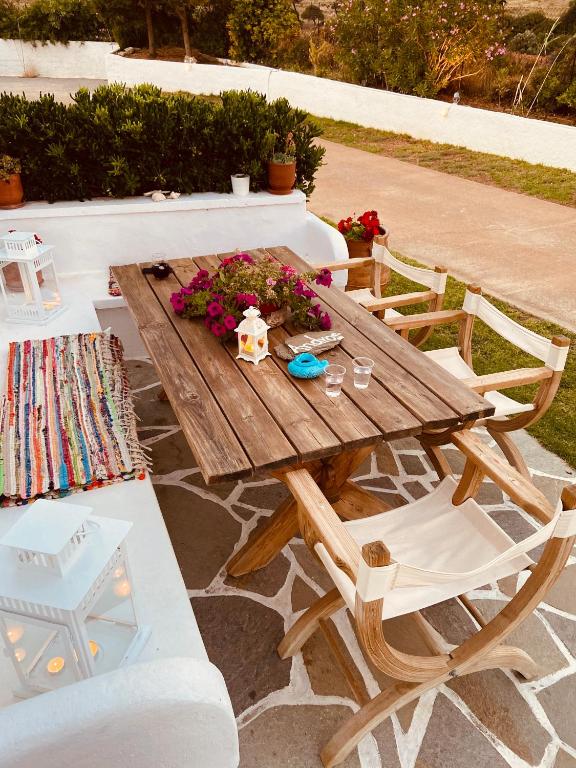 a wooden table and chairs with flowers on it at Spanos Apartments in Agios Petros
