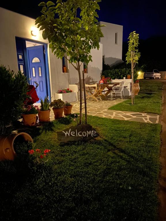 a yard with a blue door and a table with chairs at Spanos Apartments in Agios Petros