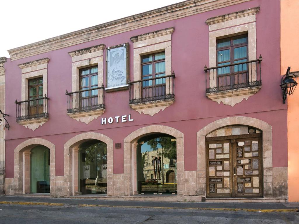 un edificio rosa con ventanas y un hotel en Hotel Casa del Virrey & Suites, en Morelia