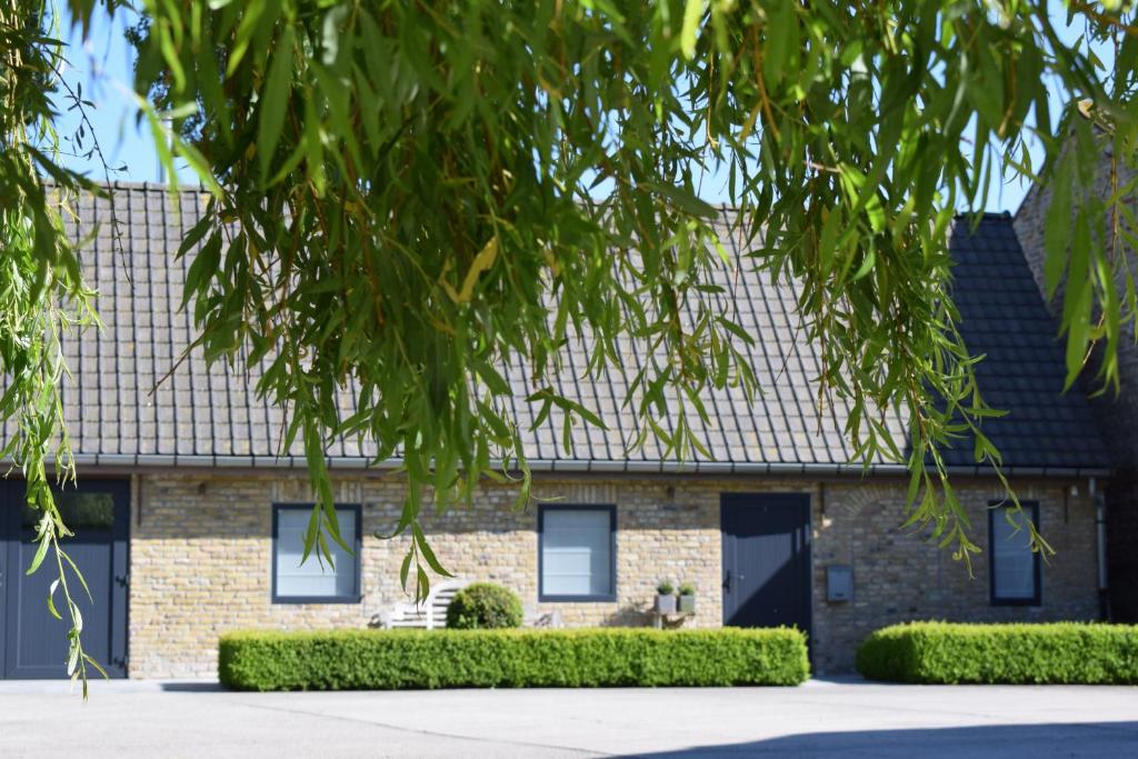 una casa de ladrillo con un árbol en Gastenverblijf ‘t Landsheertje, en Veurne