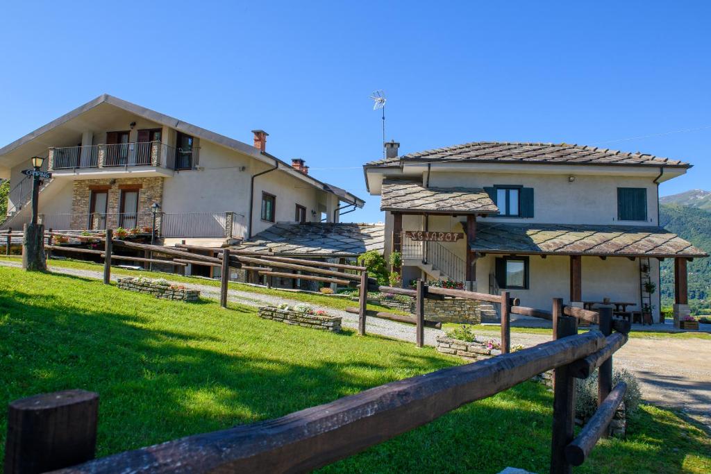 a house with a fence in front of a yard at Agriturismo L'Ciabot in Paesana