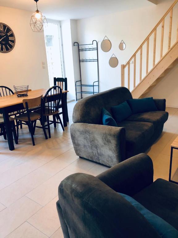 a living room with two couches and a table at Sur le chemin de la plage in Cherbourg en Cotentin