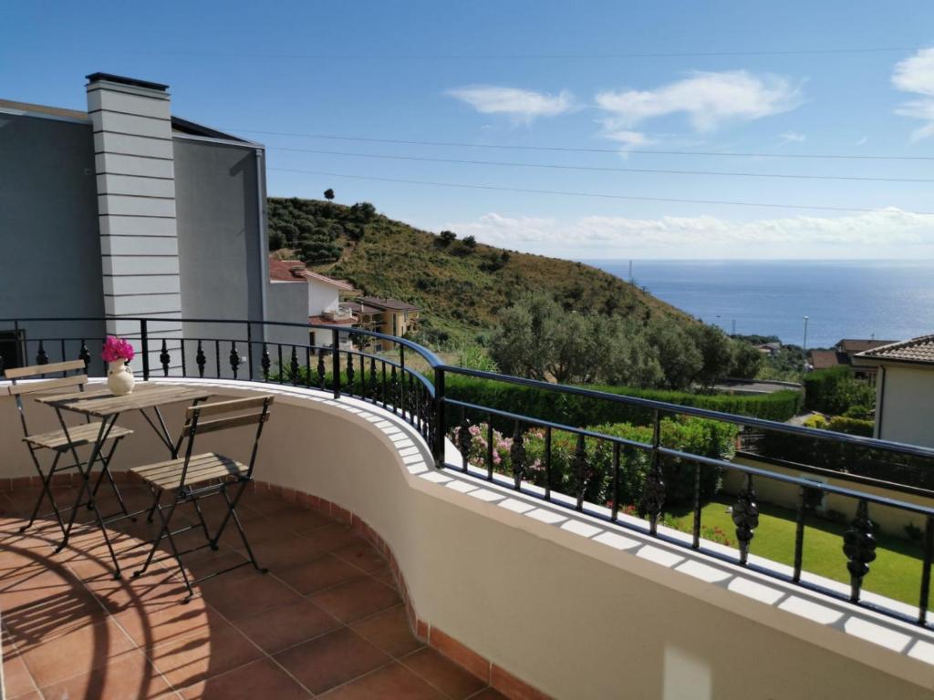 uma varanda com uma mesa e vista para o oceano em La Terrazza degli Dei em Buonvicino