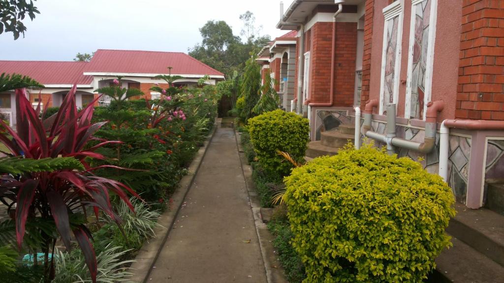 a sidewalk in front of some houses with plants at Rock Shadow Hotel in Koboko