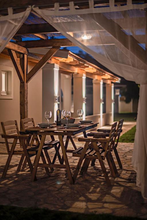 drewniany stół i krzesła na tarasie w obiekcie Villa Veneto Luxury holidays w mieście Melíssia