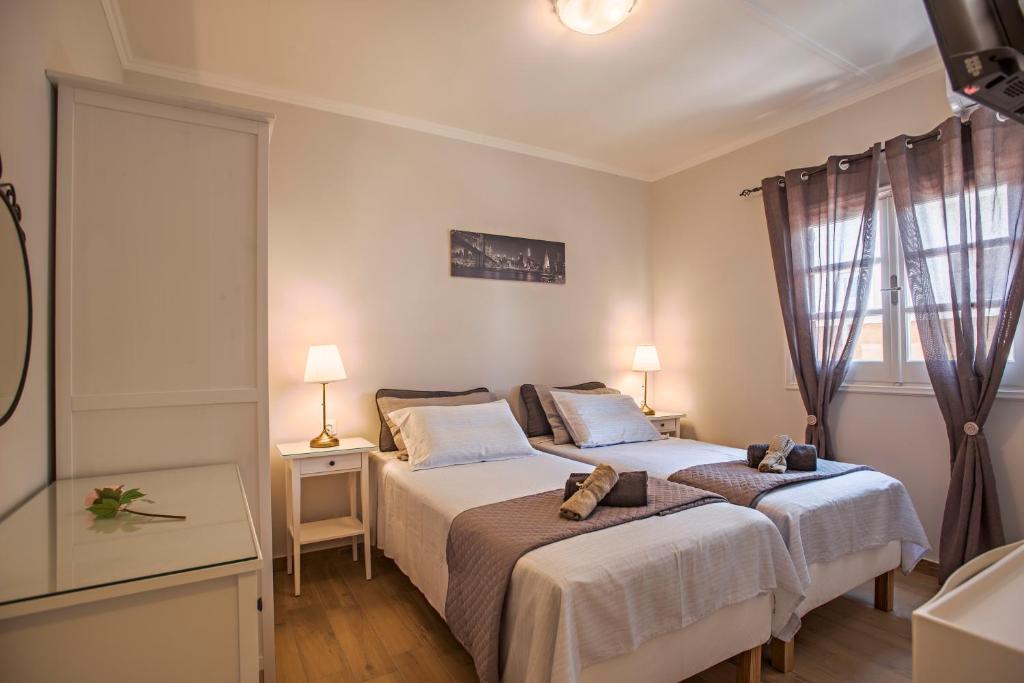 een slaapkamer met 2 bedden en een bad bij Villa Veneto Luxury holidays in Melíssia