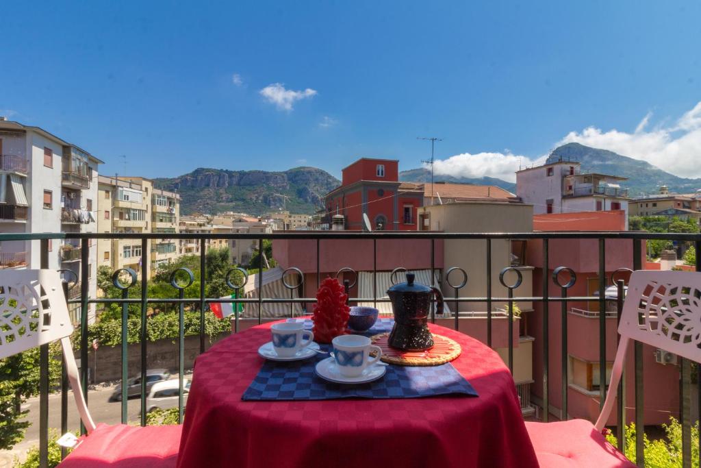 un tavolo con tazze e piattini su un balcone di Coast & Coast | Apartments a Piano di Sorrento