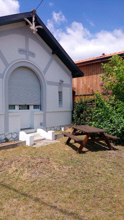 - une table de pique-nique dans une cour devant un bâtiment dans l'établissement Villa Primerose, à Andernos-les-Bains