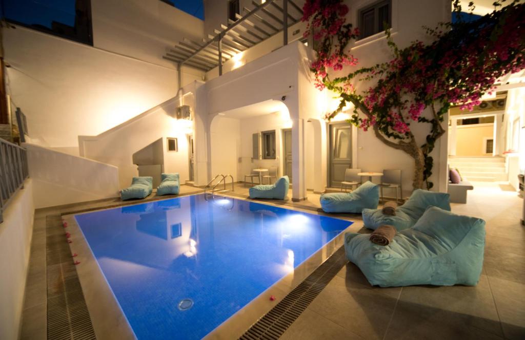 a large swimming pool with a person laying on pillows next to it at Markakis Studios Fira Town in Fira