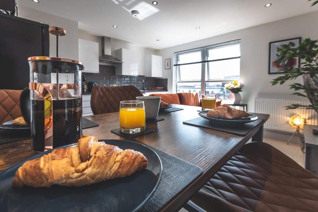 un tavolo con un piatto di pane e un bicchiere di succo d'arancia di Smart Apartments - Atlantic Mansions a Southampton