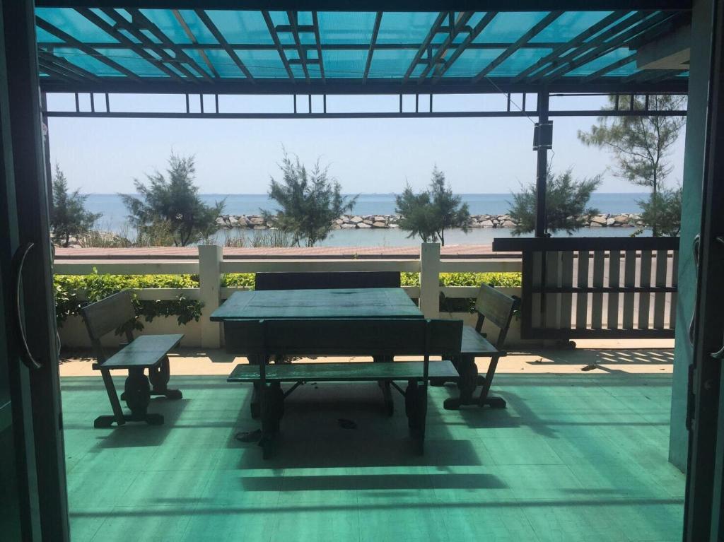 um pátio com uma mesa e cadeiras e vista para a praia em Sealife Private Beach Villa em Ban Nong Si Tong