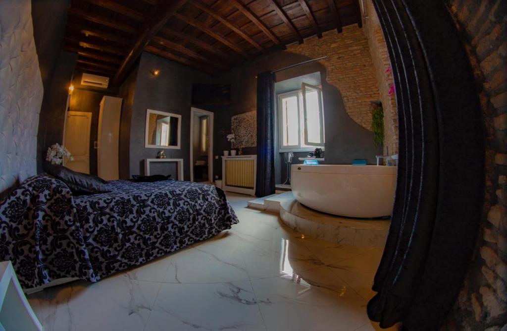 a bathroom with a tub and a bed and a mirror at Rhome Luxury suite in Rome