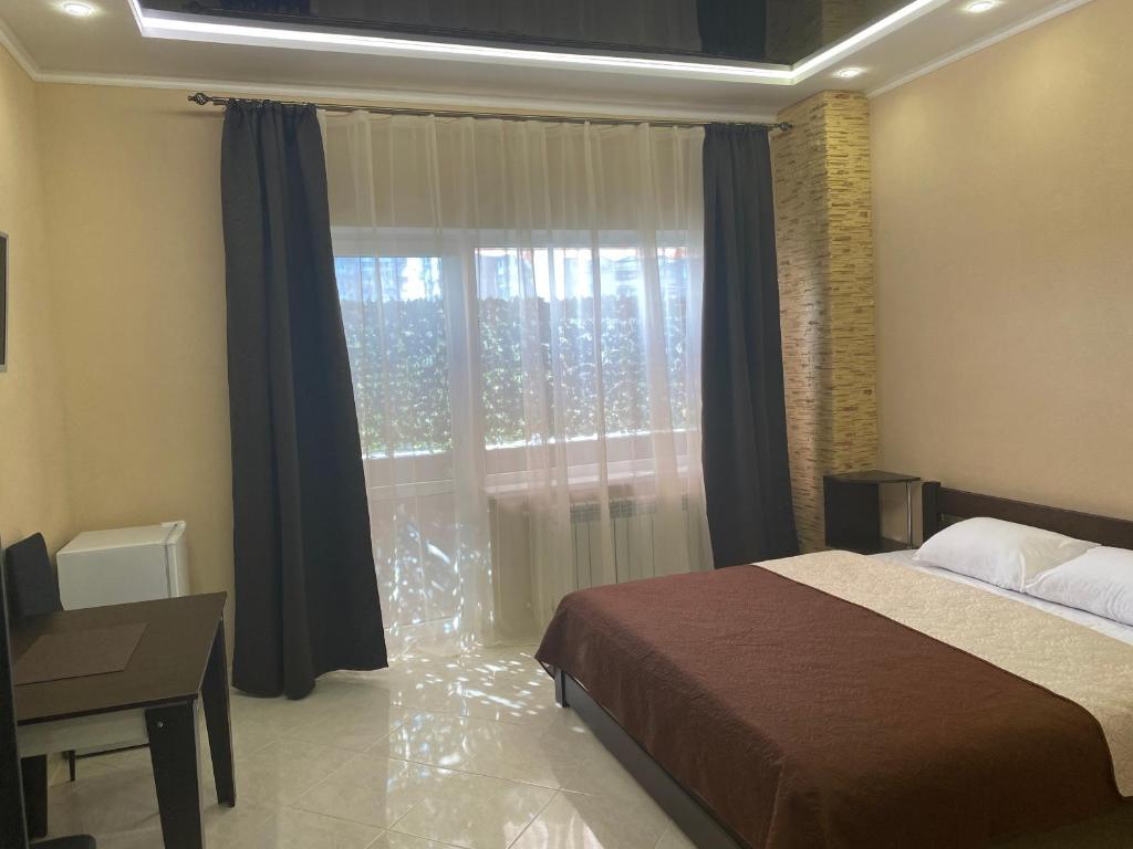 1 dormitorio con cama y ventana grande en Міні-готель "Кімната Комфорт" en Odesa