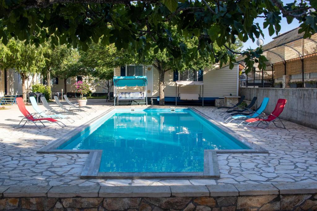 a swimming pool with chairs and a table at Mobile homes Bonaca in Srima