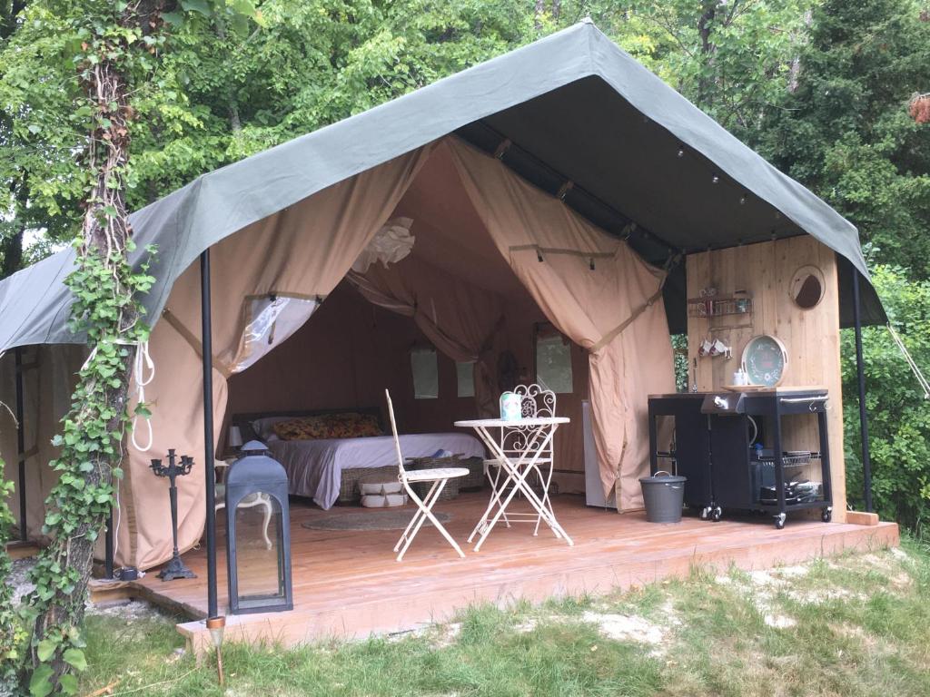 馬爾賽的住宿－Les Toiles de La Tortillère tentes luxes safari lodge glamping insolite，帐篷配有一张床和一个木制甲板