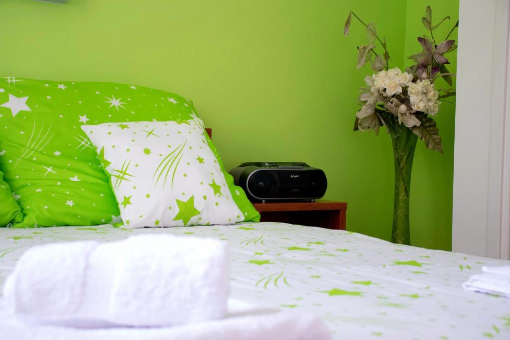 un letto con cuscino e vaso di fiori di Nilena apartmani a Smederevo