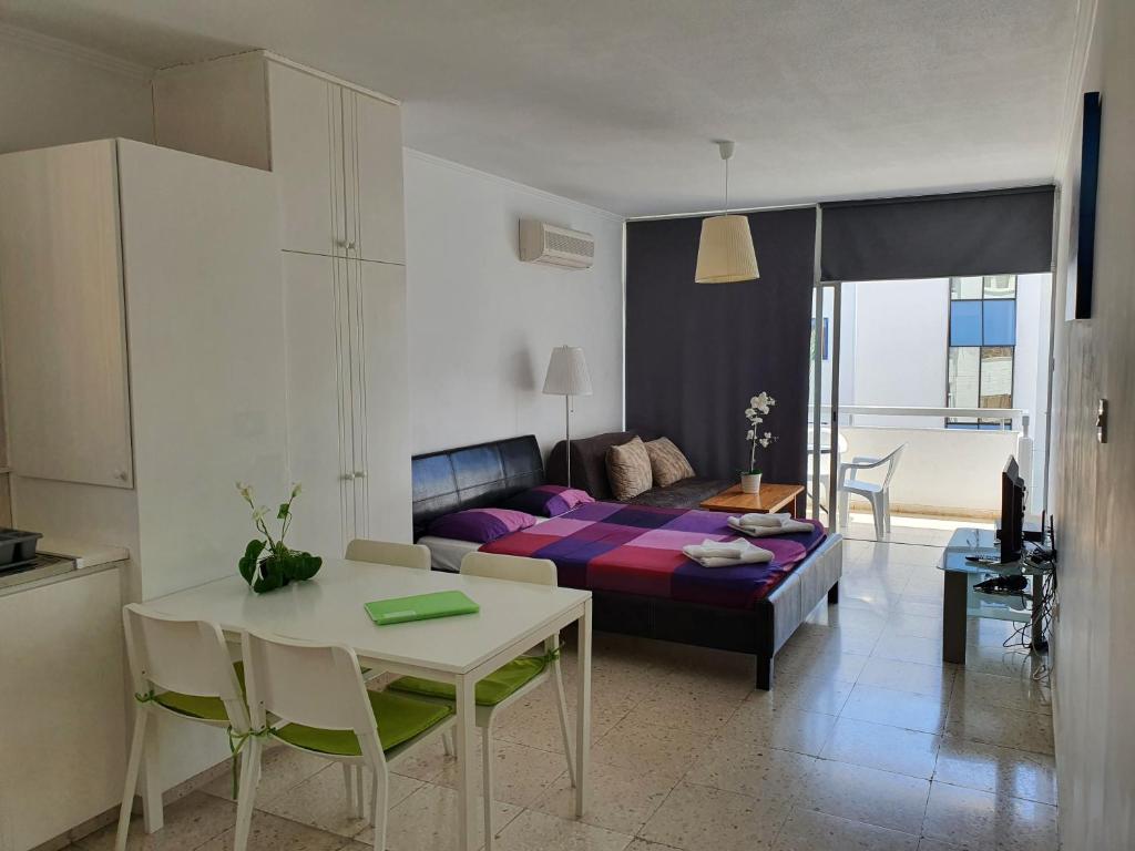 a living room with a couch and a table with a tableablish at Sea Anemone Apartments in Paphos City