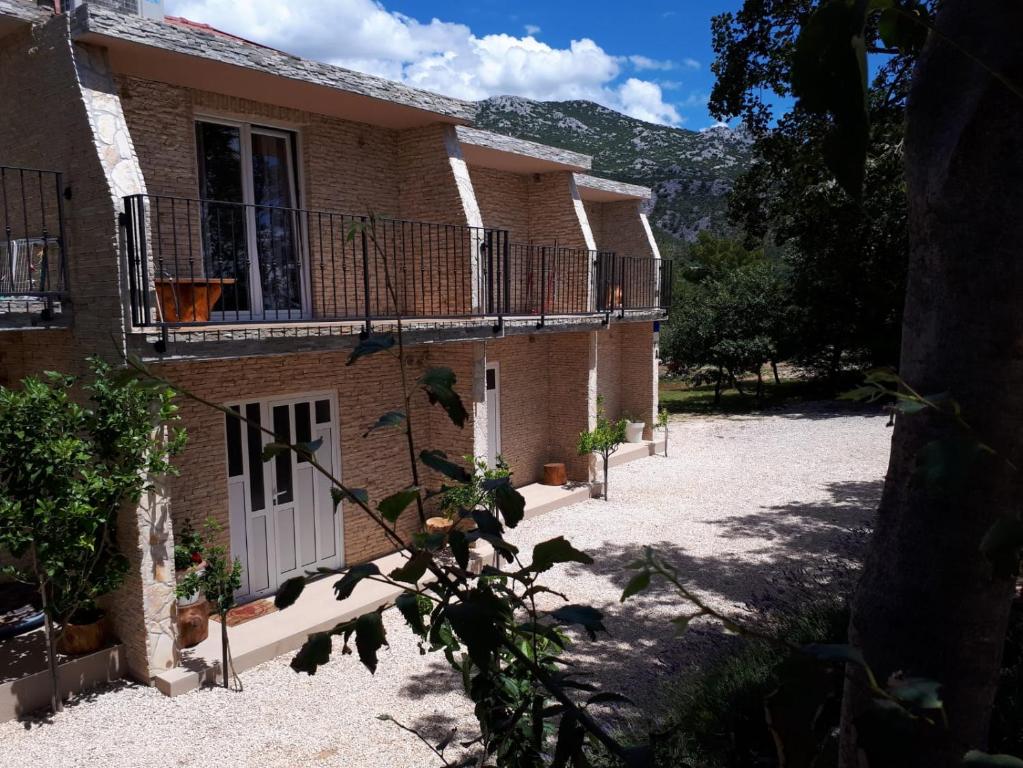 a brick house with a white door and a balcony at Amanda C in Starigrad