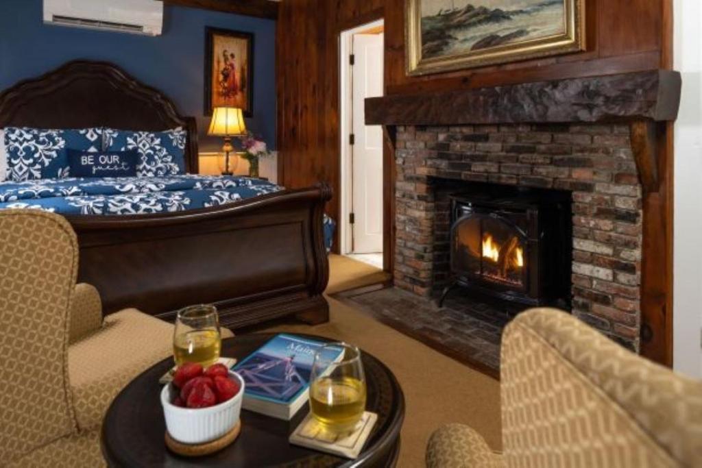 a living room with a bed and a fireplace at 1802 House Bed & Breakfast in Kennebunkport