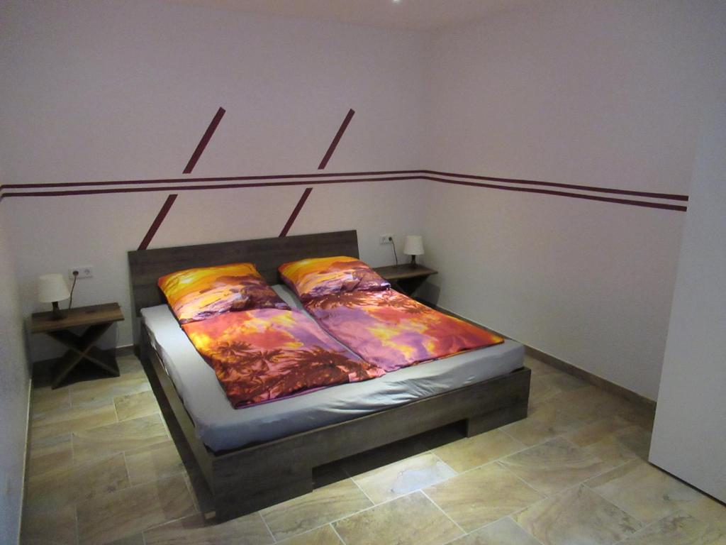 una cama con almohadas coloridas en una habitación en WeCo Ferienwohnungen, en Zirndorf