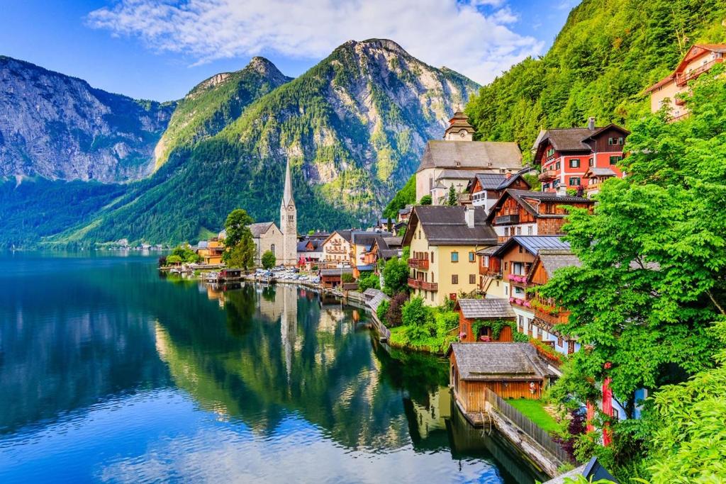 a town on a river with mountains in the background at Apartment Sophia - Hallstatt in Hallstatt