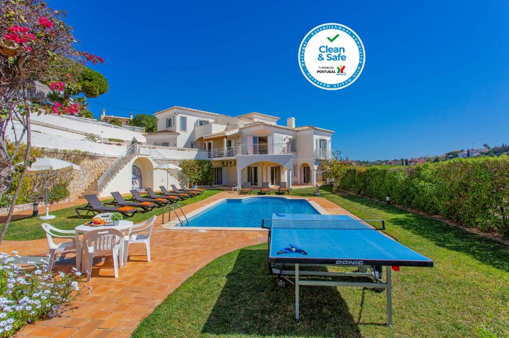 a house with a pool and a ping pong table at Vivenda Vista Mar in Carvoeiro