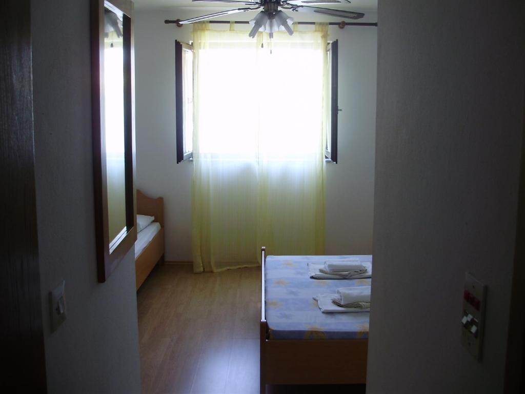 a room with a table and a window with a ceiling fan at Villa Welcome in Vrboska