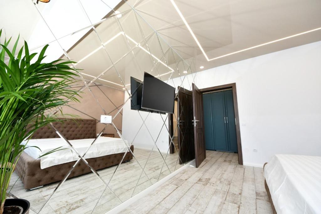 Zimmer mit einem TV und einem Bett. in der Unterkunft Sweet Luxury - CentralPark in Galaţi