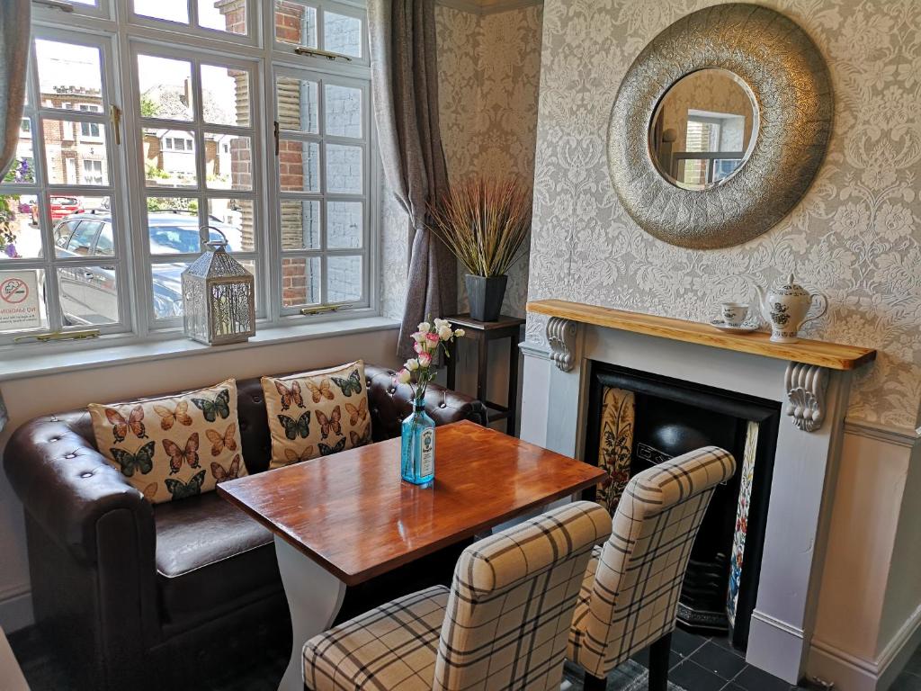 a living room with a table and a fireplace at Woolpack Inn in Chichester