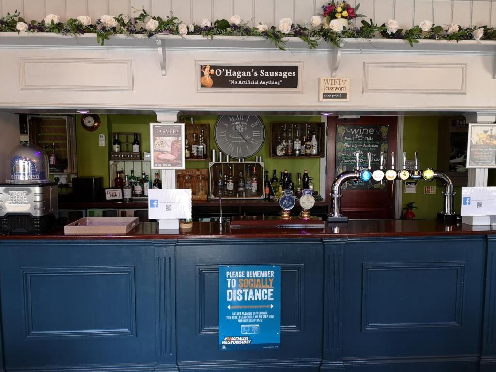 a bar with a blue counter with a sign on it at Woolpack Inn in Chichester