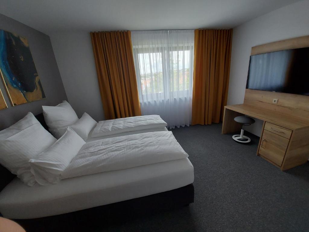 ein Hotelzimmer mit einem Bett und einem TV in der Unterkunft Ferienwohnung Nikolena in Pirmasens