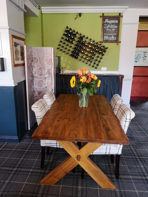 a wooden table with a vase of flowers on it at Woolpack Inn in Chichester