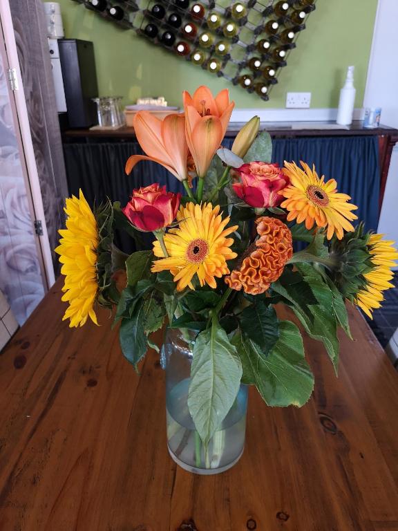 a vase filled with flowers on a wooden table at Woolpack Inn in Chichester
