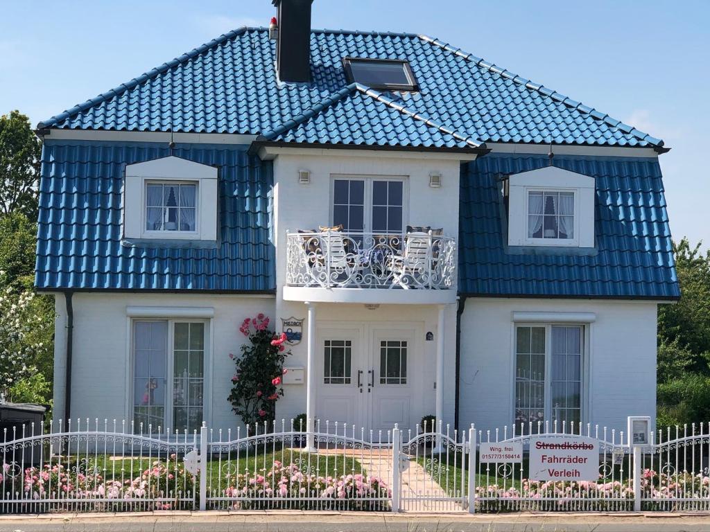 uma casa branca com um telhado azul em Strandvilla Kalifornien direkt am Meer em Kalifornien
