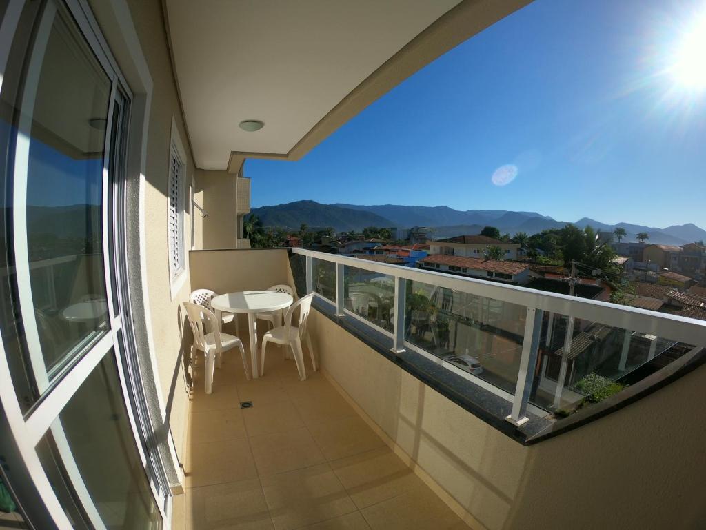 balcón con mesa, sillas y vistas en Beach House Itaguá Apartamento 1 - Em Ubatuba a 300m da orla mais charmosa, com excelente localização en Ubatuba