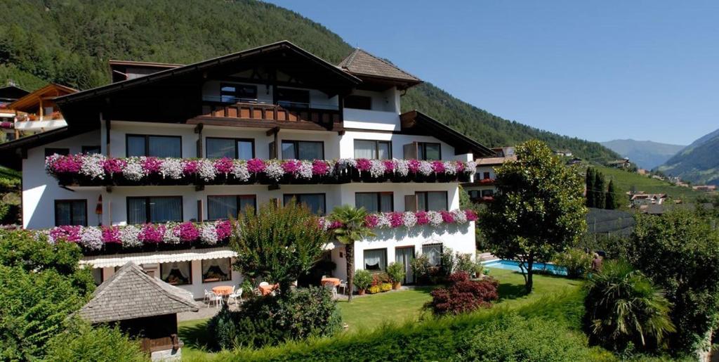 a building with flowers on the side of it at Pension Kleon in Rifiano