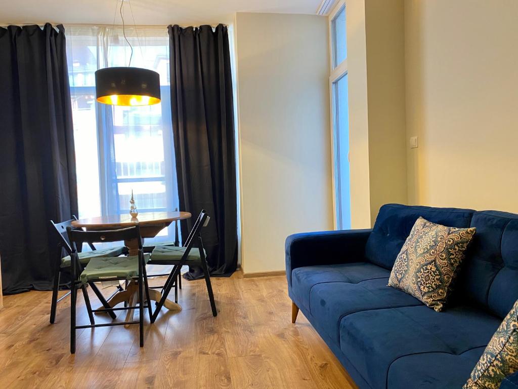 uma sala de estar com um sofá azul e uma mesa em Boutique Magenta Gold Apartment em Sófia