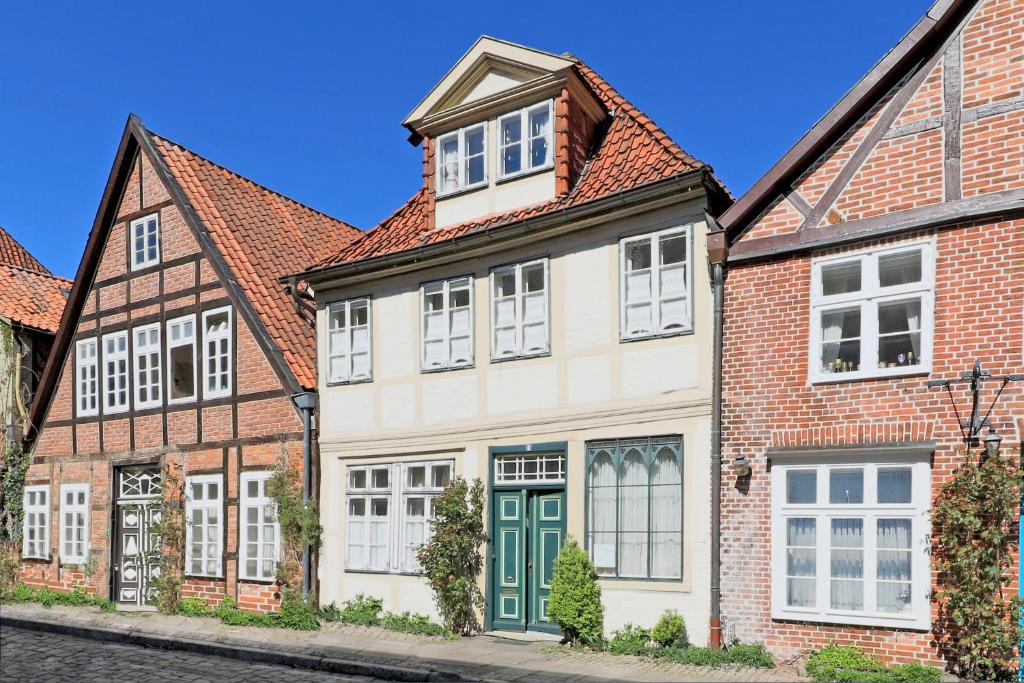 Biały dom z czerwonym dachem w obiekcie Rosenstock Apartments Lüneburg w mieście Lüneburg