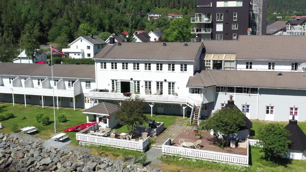 Å i Åfjord的住宿－Fosen Fjord Hotel，一座白色的大建筑,有院子和房子
