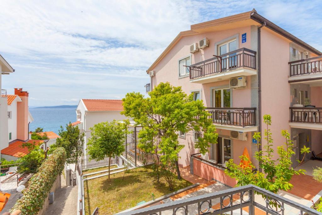 a building with balconies and the ocean in the background at APARTMANI GRBAVAC in Baška Voda