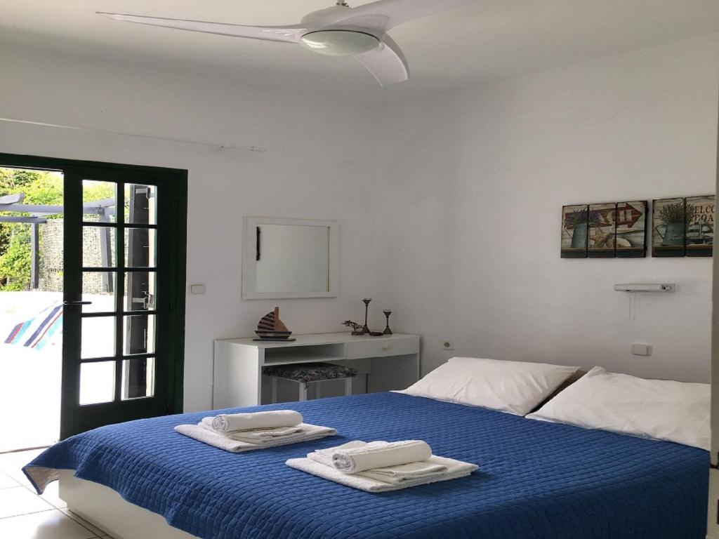 Un dormitorio con una cama azul con toallas. en Aigialis Apartments & Studios, en Kokkíni Khánion