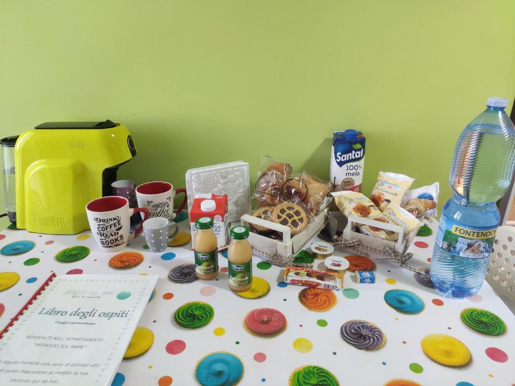 a table topped with donuts and other food and drinks at Appartamento Affaccio sul mare, Baia di Copanello in Copanello