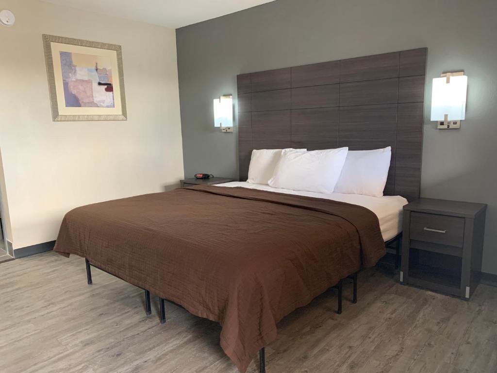 ein Schlafzimmer mit einem großen Bett in einem Hotelzimmer in der Unterkunft Crescent Park Motel & Suites in Littlefield