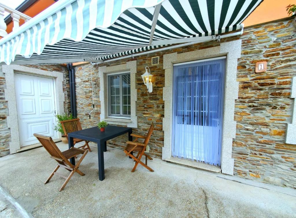 a patio with a table and chairs and a building at Apartamentos Turísticos Rosa in Ribadeo